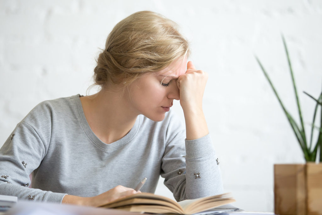 woman having a vertigo while reading