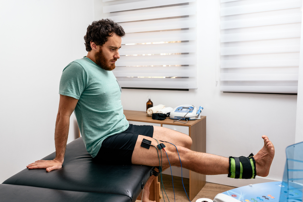 man having a electrotherapy on his leg