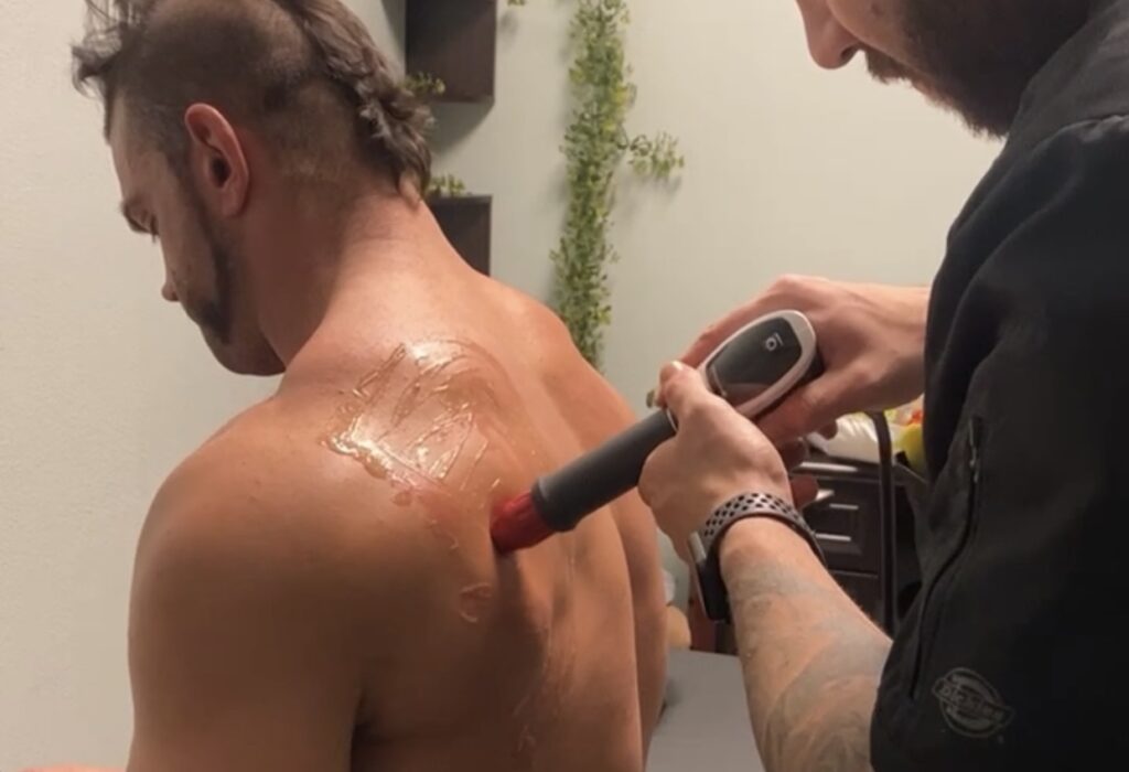 man having a shockwave therapy on his back