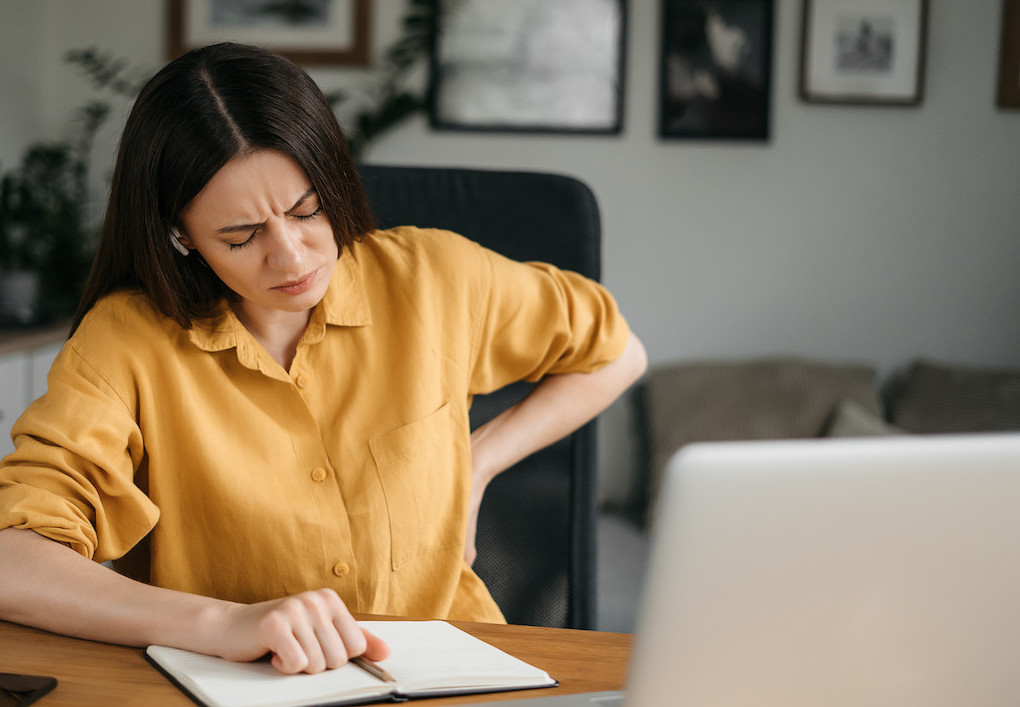 woman having a lower back pain while doing her work