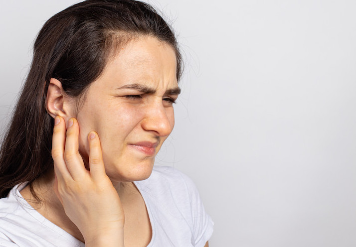 The woman has a sore ear - infection, inflammation from infection and otitis. Perforation ruptured the eardrum. Arthritis of the temporal lower jaw joint, osteoarthritis and pain in the jaw, mastoiditis.